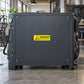 Danger compressed air warning sticker on dark gray industrial air compressor panel