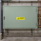 Danger hot water return warning sticker with yellow hazard icon on a metal panel