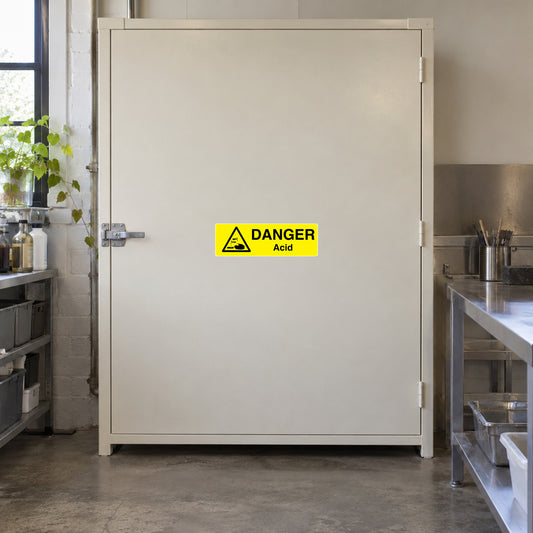 Yellow warning sticker with black hazard triangle and 'DANGER' 'Acid' text