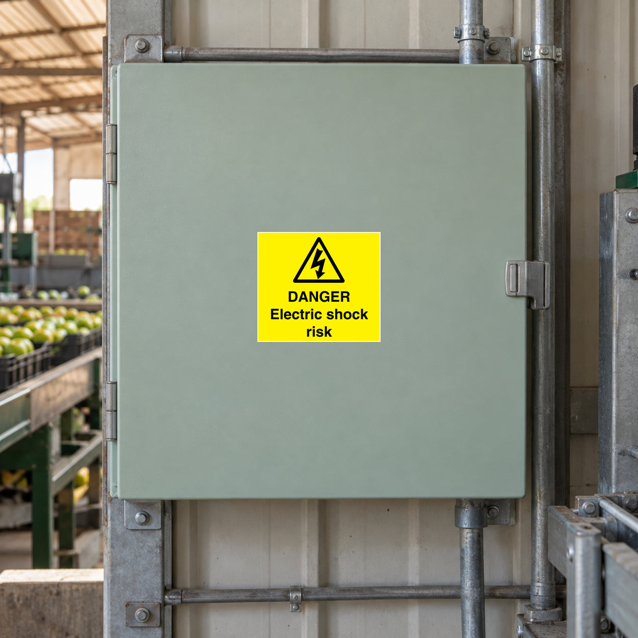 Warning electric shock risk sticker on gray metal electrical enclosure door
