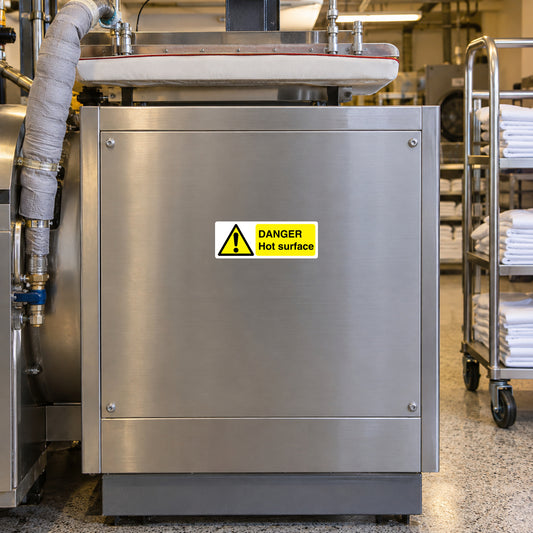 Danger Hot Surface sticker on a commercial laundry steam-press service panel