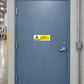 Safety warning sticker with exclamation icon and text on a door