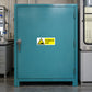 Sulfuric acid danger warning sticker on blue cabinet door