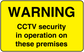 Yellow CCTV warning sticker with black text: WARNING CCTV security in operation on these premises