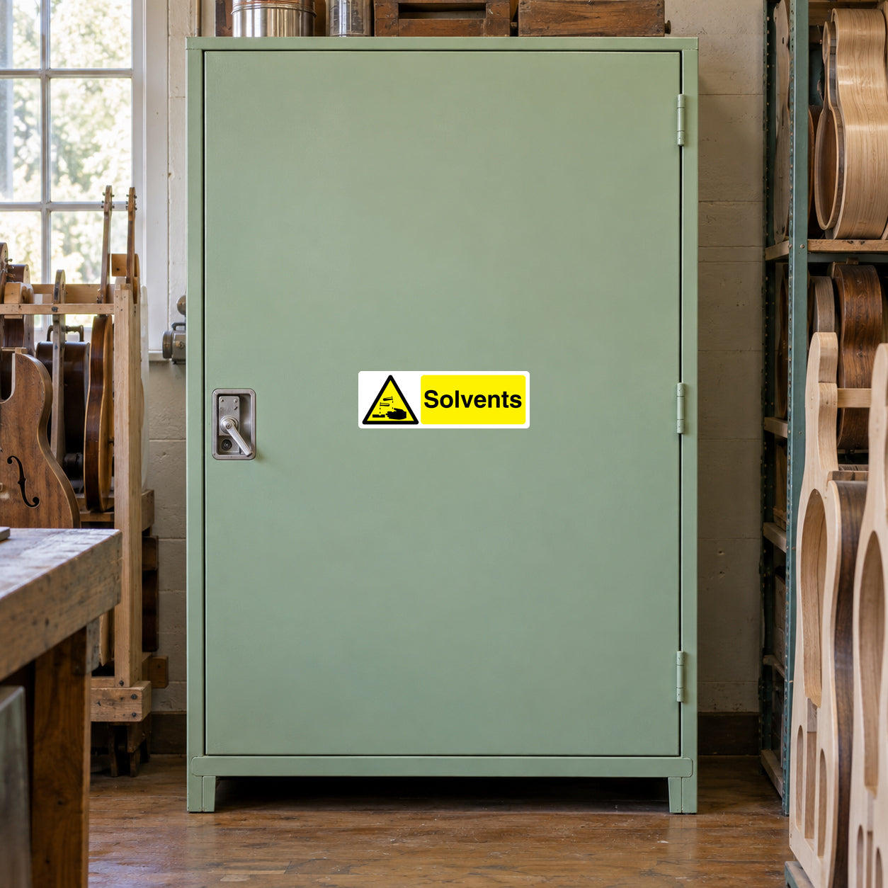 Warning label sticker on green metal cabinet door, Solvents hazard sign