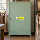 Warning label sticker on green metal cabinet door, Solvents hazard sign