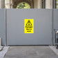 Danger warning sticker on gray metal safety panel, yellow with black exclamation