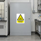 Danger Carcinogen Sticker applied in Closed broad light-gray chemical storage cabinet in an industrial research laboratory, smooth single central door, lock far right, fume hood edge far left.