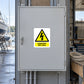 Danger 240 Volts Sticker applied in Closed broad light-gray electrical cabinet in a boatyard maintenance workshop, unbroken central door, latch far left, marine workbench and coiled rope far right.