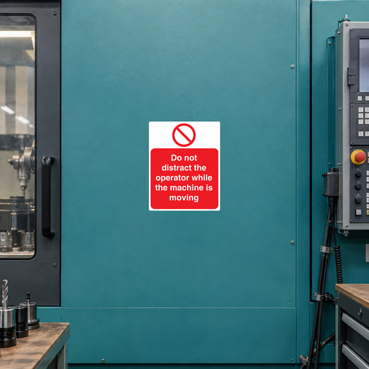 Square warning sticker with red text: "Do not distract the operator while the machine is moving"
