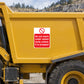 Safety warning sticker on yellow equipment: do not reach under raised body unless propped.