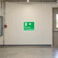 Exit Only In Emergency Safety Sign Sticker applied in secured factory emergency escape corridor, smooth cream wall, emergency exit at extreme right, unobstructed floor