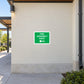 Green fire assembly point sign sticker with arrows pointing left and down
