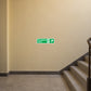 Green emergency stairs up-right exit sticker with white arrow on wall