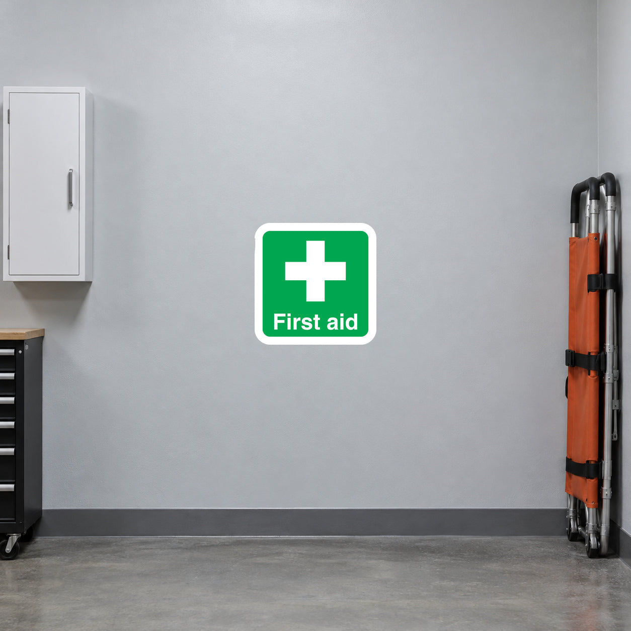 Green first aid sticker with white cross and 'First aid' text