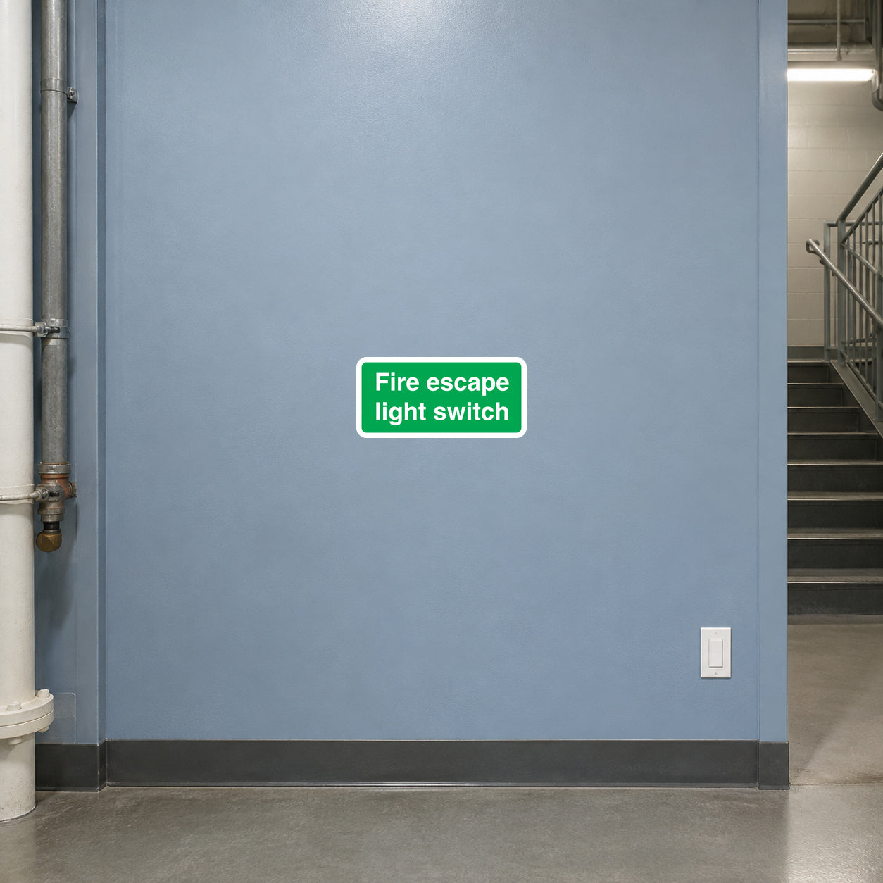 Fire escape light switch sticker with green label text on wall near a light switch