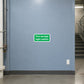 Fire escape light switch sticker with green label text on wall near a light switch