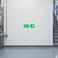 Green fire exit sign sticker with running person and arrow for emergency escape