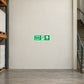 Green fire exit sticker with running person and right arrow and straight arrow