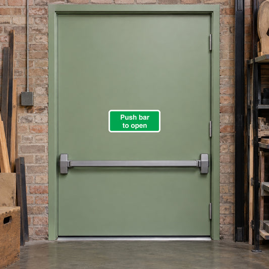 Green safety sticker reading "Push bar to open" on a door