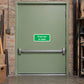 Green safety sticker reading "Push bar to open" on a door