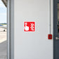 Fire button location sticker with red fire alarm icon on light metal door