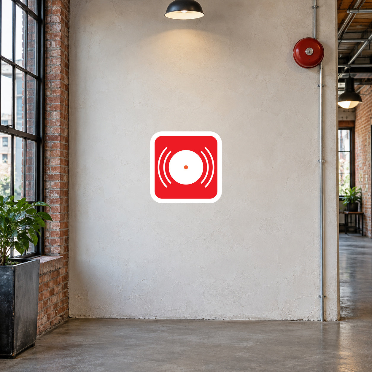 Fire alarm bell symbol sticker in a converted factory corridor