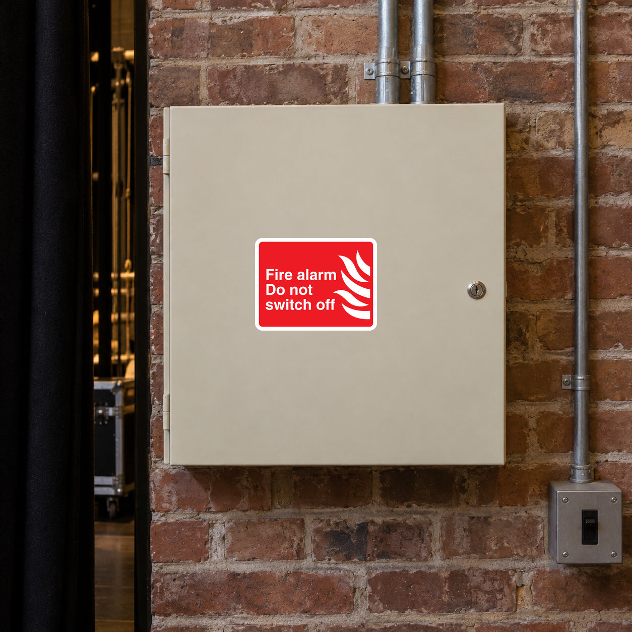 Fire alarm sticker reading “Do not switch off” with red flame icon on white backing