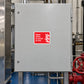 Red fire safety sticker with white text and flame icon: 'Open valve in event of fire'