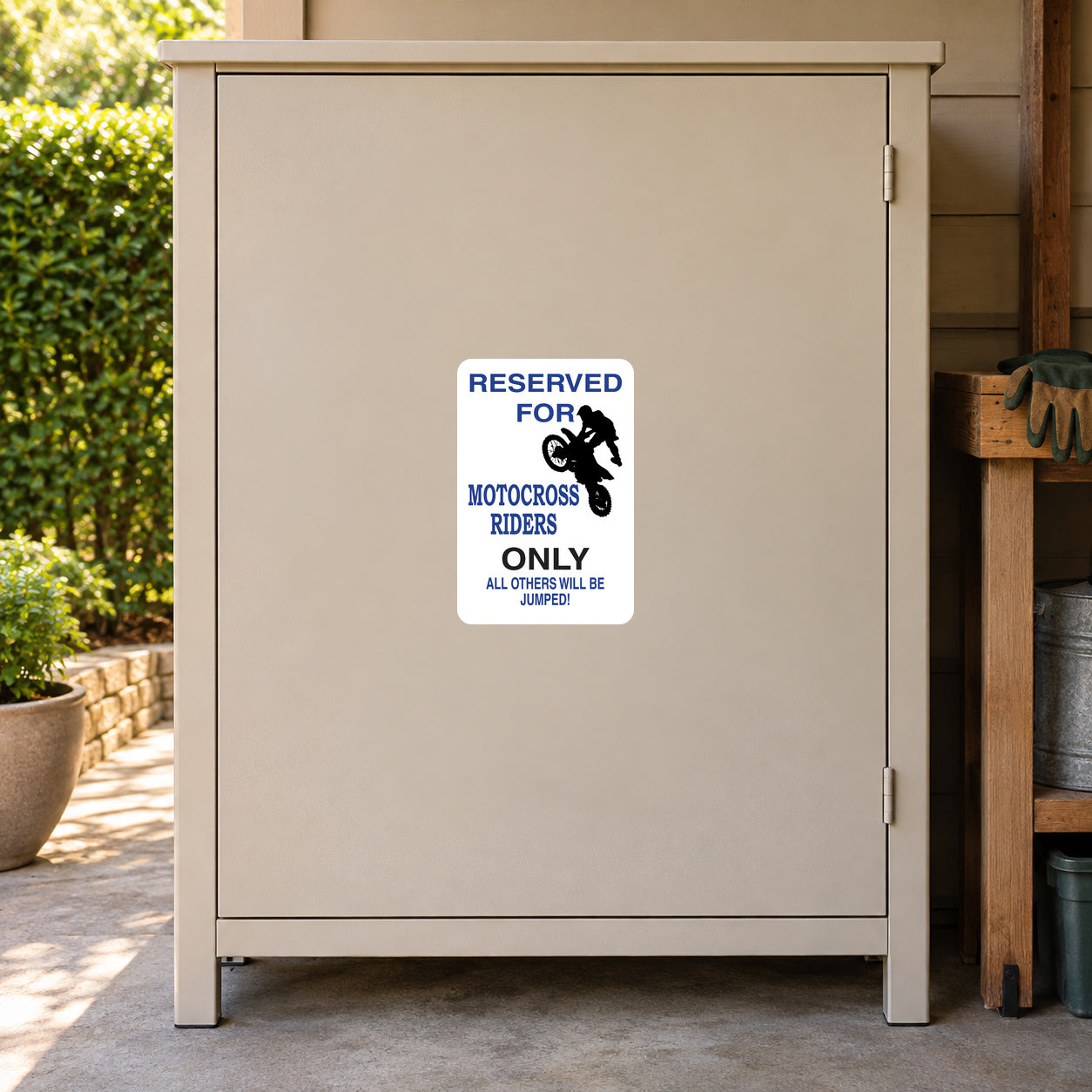 White sign sticker with blue “Reserved for motorcross riders only” text