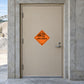 Hazardous warning sign sticker with orange explosive symbol on smooth surface