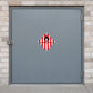 Hazardous Safety Sign Sticker applied in a specialized materials store with pale brick outer walls, smooth grey SINGLE-door steel cabinet front, latch at extreme left
