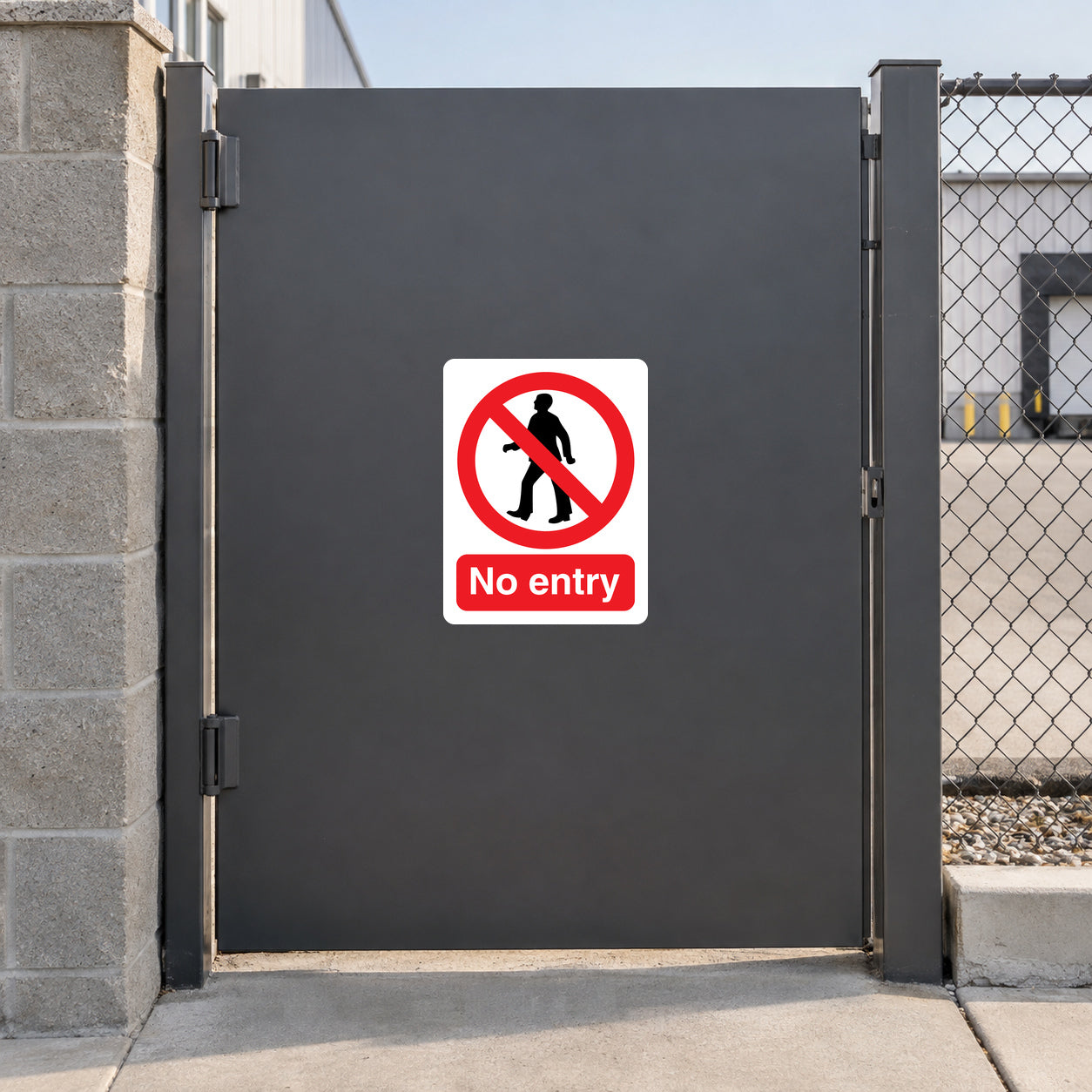NO Safety Sign Sticker applied in a restricted loading-yard pedestrian entrance, smooth charcoal SINGLE solid gate panel, masonry post and fenced yard outside edges