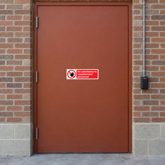 NO Safety Sign Sticker applied in private distribution center records room entrance, solid rust-colored door, brick frame and card reader extreme right