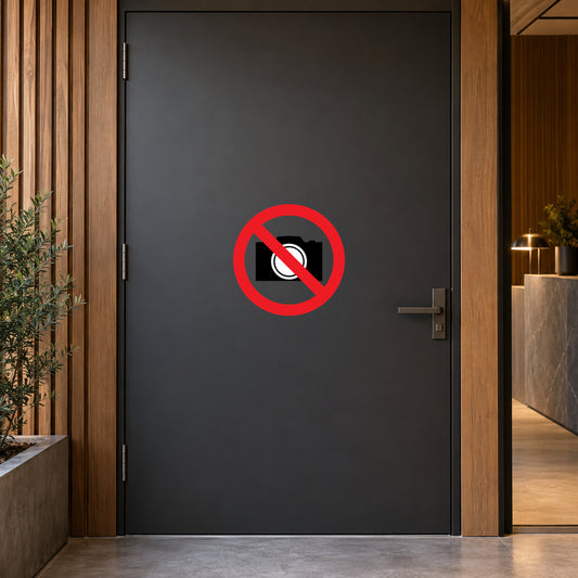 NO Safety Sign Sticker applied in confidential design studio entrance, smooth solid charcoal door, timber surround and reception glimpse at far right