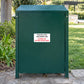 No Dogs sign sticker on green trash bin: red 'CLEAN UP AFTER YOUR DOG!'