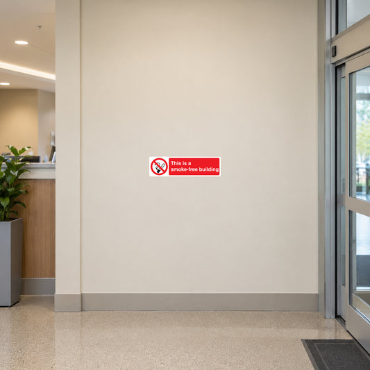 NO Smoking Sign Sticker applied in cream hospital lobby wall beside automatic entrance edge, no windows centrally