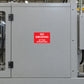 No smoking sign sticker with red background and white text on gray metal door