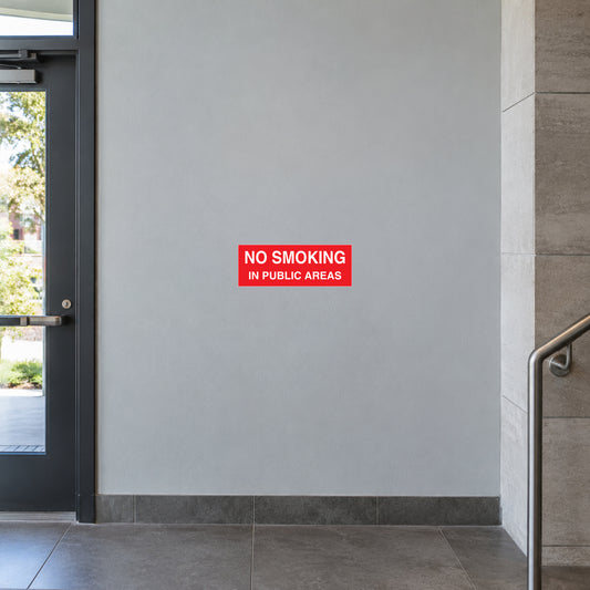 NO Smoking Sign Sticker applied in pale grey municipal building foyer wall beside an entry door