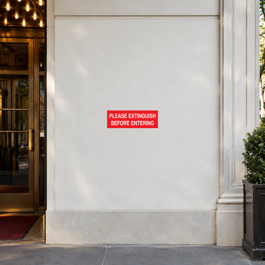 NO Smoking Sign Sticker applied in smooth white wall beside a theater entrance threshold