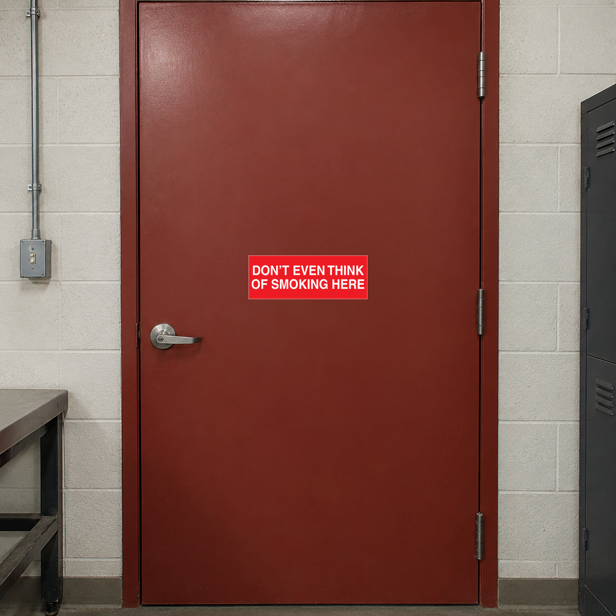 NO Smoking Sign Sticker applied in single muted red workshop breakroom door