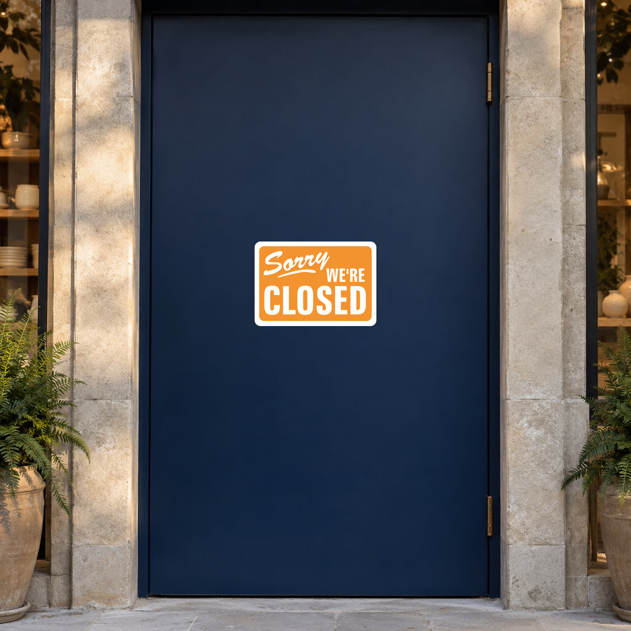 Business Open Closed Sign Sticker applied in a closed ceramics boutique entrance, smooth solid midnight blue door, polished stone jamb and potted fern only at far edges, late afternoon