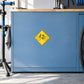 Yellow bicycle road sign sticker in diamond shape on blue surface