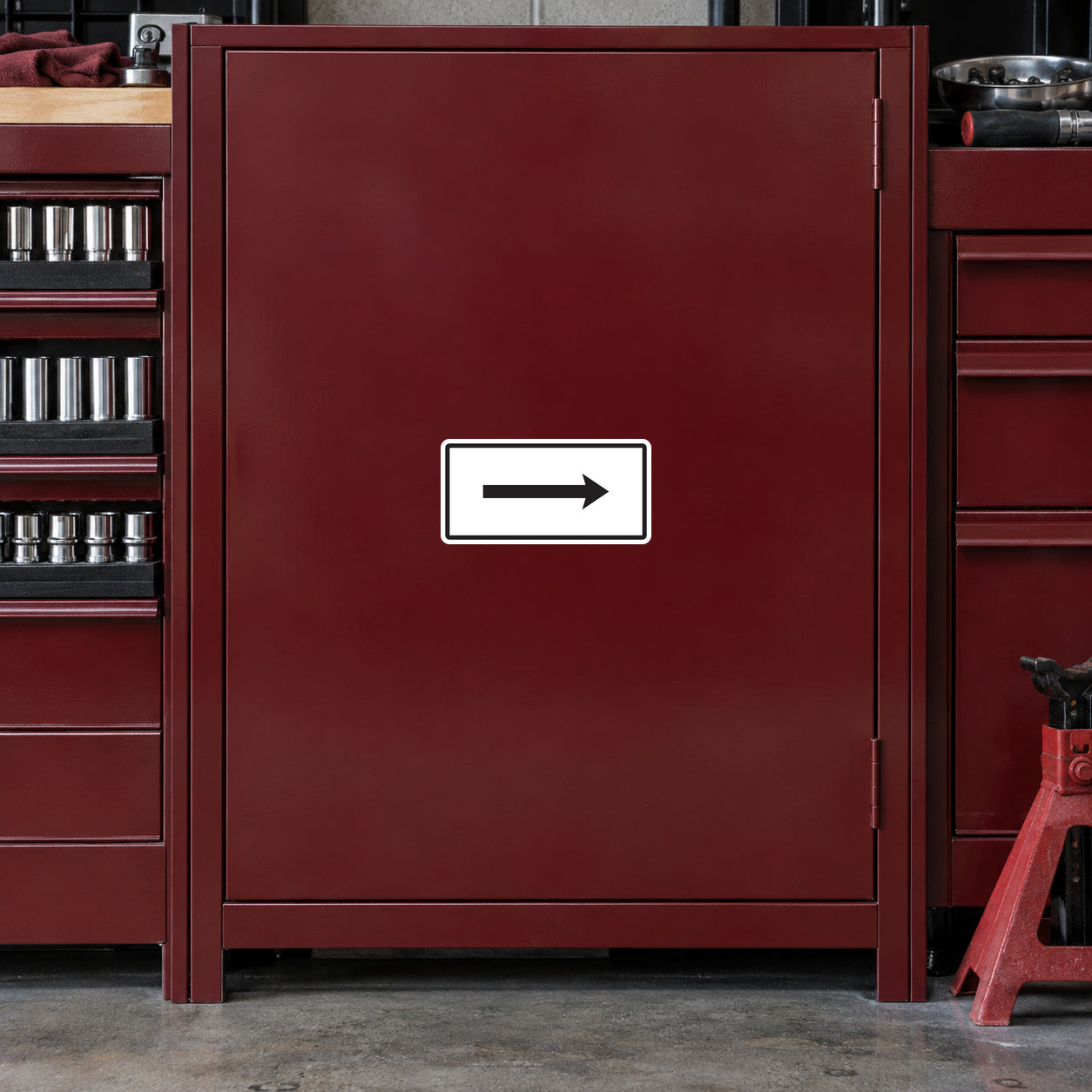 Road sign sticker: white panel with black right-arrow on red metal door