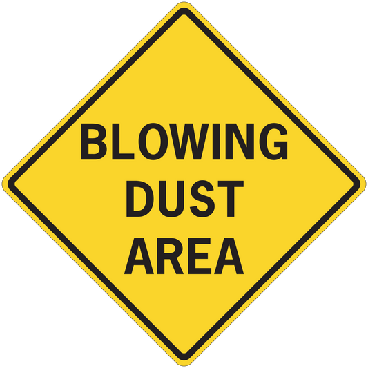 Road sign sticker: yellow diamond with black border, 'BLOWING DUST AREA' text.