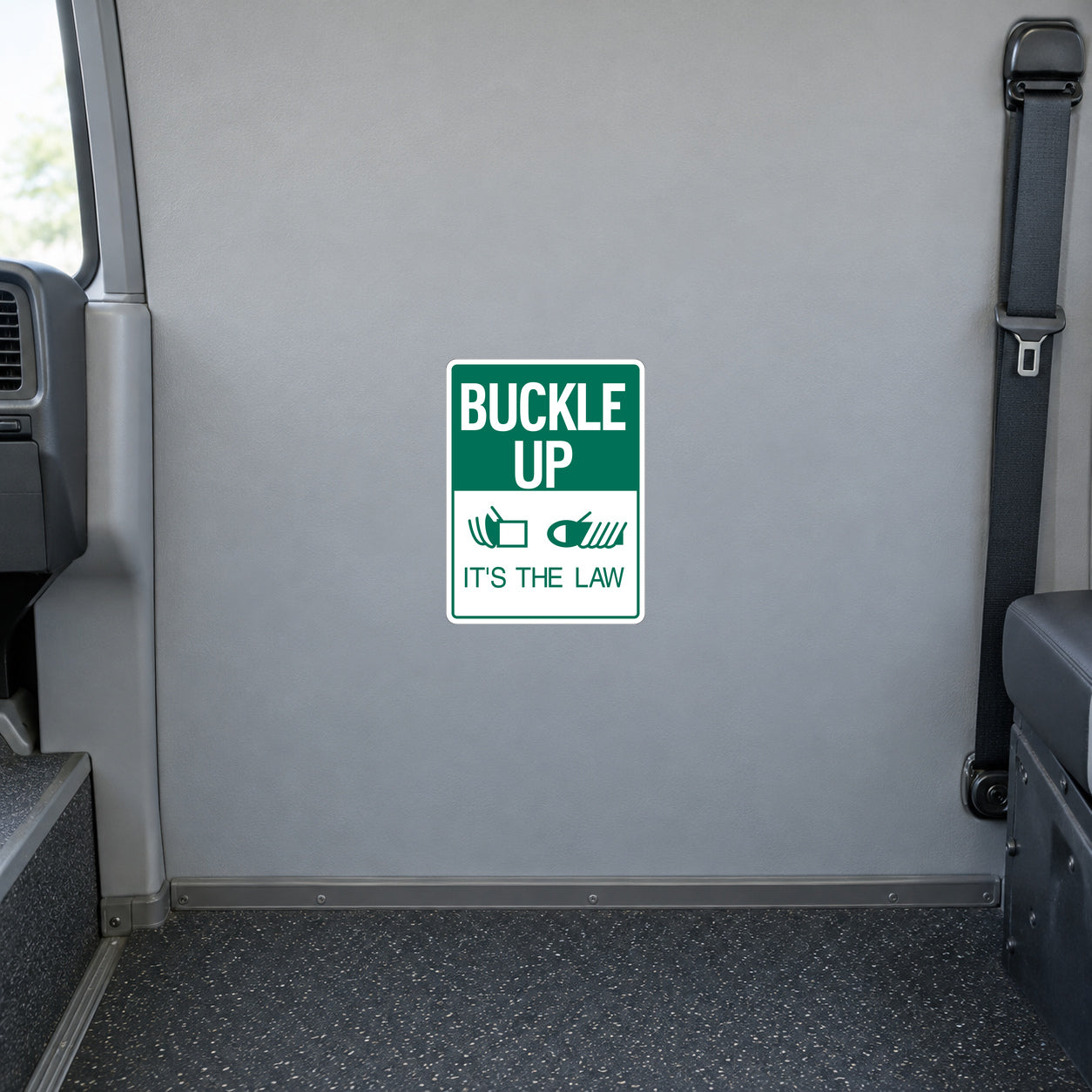 Square road sign sticker with green border and text “BUCKLE UP” and “IT'S THE LAW”