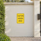 Yellow road sign sticker with CAUTION HIDDEN DRIVE text
