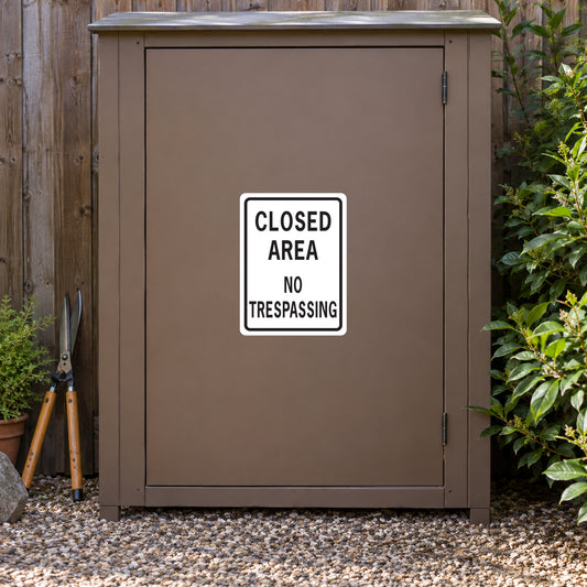 Road sign sticker: "CLOSED AREA NO TRESPASSING" on white square