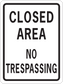 Road sign sticker with black border and text: CLOSED AREA, NO TRESPASSING