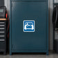 Road Sign Sticker applied in A dark teal auto electrical workshop cabinet with battery tester extreme left and coiled cable far right, blank smooth single door